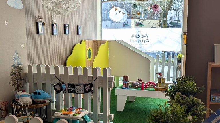 Einer der Spielebereiche des Keks & Krümels, ein Krabbebereich, eine Rutsche und ein Spieltisch mit Schienen