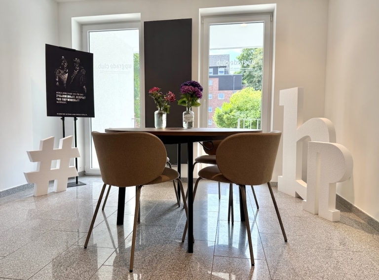 Heller Schulungsraum des Upgrade Club Recklinghausen mit rundem Tisch, vier Stühlen.