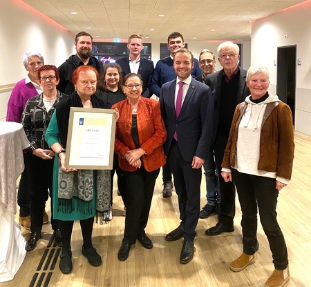 Marianne Masberg mit der Auszeichnung zur "Bürgerin des Jahres" im Kreise zahlreicher Gratulantinnen und Gratulanten. 