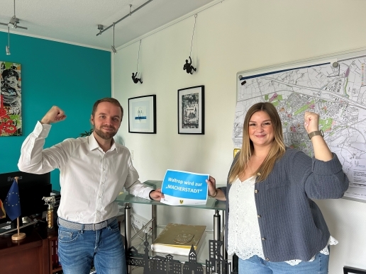 Bürgermeister Marcel Mittelbach (links) und Mitarbeiterin Melissa Neuman halten einen Zettel zur Macherstadt in die Höhe.