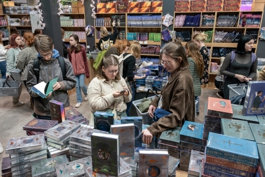 Mehrere Personen an einem Stand der Leipziger Buchmesse; sie lesen zum Teil in Büchern.