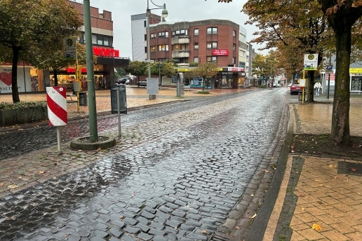 Blick auf die Hochstraße in Höhe Woolworth in Waltrop; rechts eine Bushaltestelle, links das Gebäude der Woolworth. 