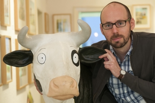 Autor und Illustrator Alexander Steffensmeier mit einer Kuhfigur (Kopf).