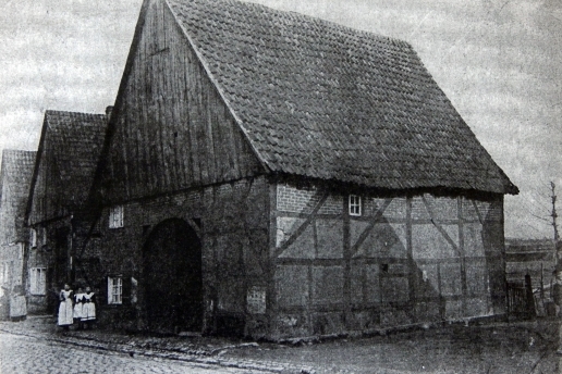 Schwarz-Weiß-Foto eines Fachwerkhauses in Waltrop, davor stehen drei Personen.