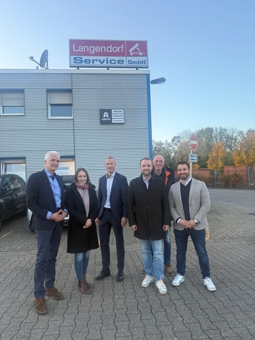 Fünf Männer und eine Frau stehen beim Besuch der Delegation der Stadt Waltrop und des V+E Waltrop vor dem Gebäude der Langendorf Service GmbH.
