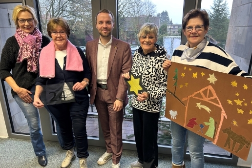 Vier Frauen der Frauen Union Waltrop stehen mit Bürgermeister Marcel Mittelbach und mit Fensterbildern vor einem Rathaus-Fenster. 