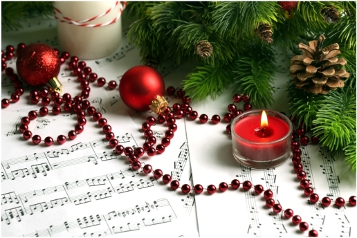 Symbolbild: Weihnachtslieder. Motiv: Weihnachtsschmuck auf Notenblättern.