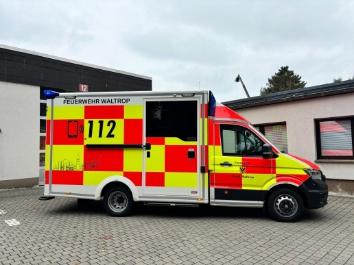 Ein gelb-orangefarben foliertes Rettungsdienst-Fahrzeug der Feuerwehr Waltrop.