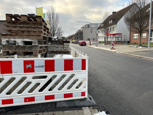 Baustellenzaun, Baumaterialien, die Hochstraße in Waltrop, Häuser, Autos und Gehwege.