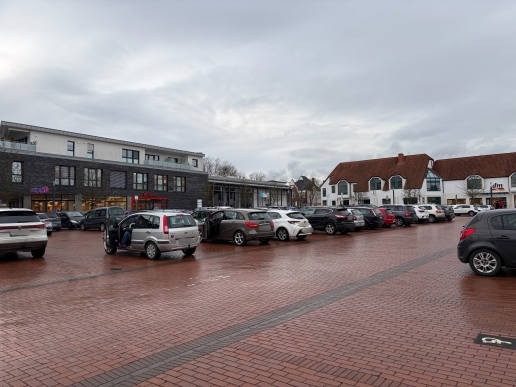 Blick auf den Marktplatz der Stadt Waltrop mit parkenden Autos, im Hintergrund die Stadthalle.