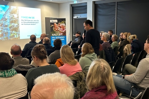 Frank Adamski steht bei der Auftaktveranstaltung Macherstadt im Foyer der Stadthalle Waltrop in den Zuschauerreihen und ist im Gespräch mit Gästen.
