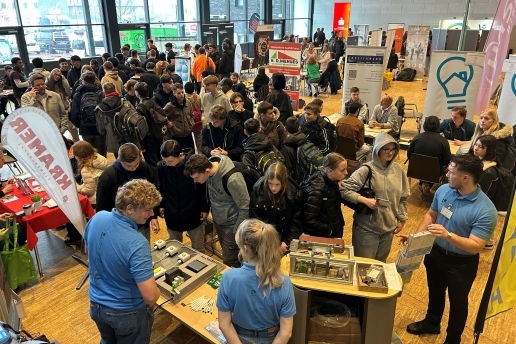 Blick in die Stadthalle bei der Ausbildungsmesse 2025: Junge Leute schauen sich an Messeständen um.
