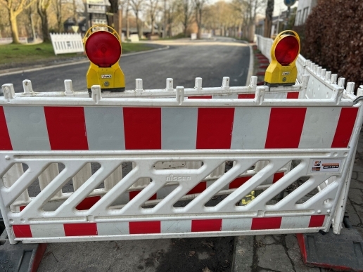 Straßensperre in Rot-Weiß, mit Lampen, im Hintergrund die Fahrbahn der Sydowstraße.