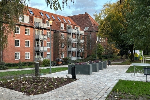 Hochbeete im Stutenteichpark, drum herum Wege, Bäume, Bebauung, Beete. 