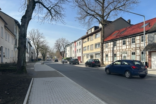 Blick auf die Fahrbahn der Hochstraße in Waltrop, am Rande Häuser, Autos, Bäume. 