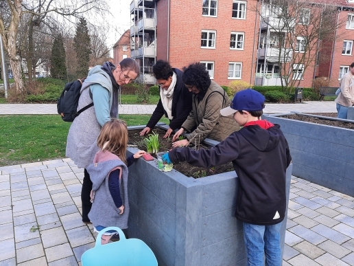 Drei Frauen und zwei Kinder stehen an einem Hochbeet im Stutenteichpark Waltrop.