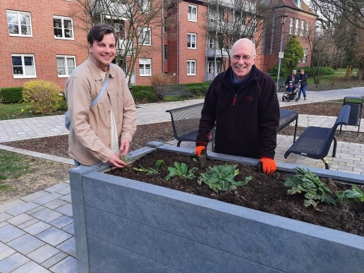Zwei Männer stehen an einem Hochbeet im Stutenteichpark. 