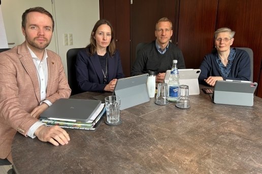 Zwei Männer und zwei Frauen - der Verwaltungsvorstan der Stadt Waltrop - sitzen an einem Tisch, vor ihnen Tablets, Unterlagen, Gläser, eine Wasserflasche.