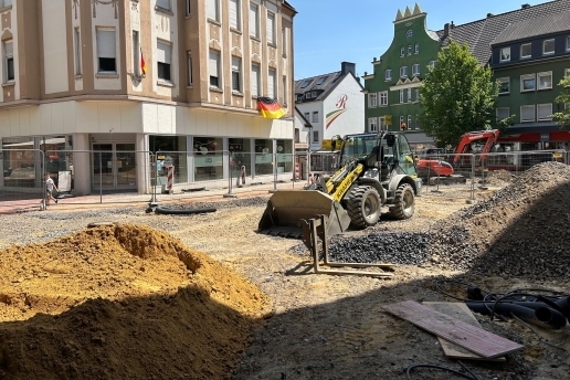 Blick auf die Baustelle Platz von Gardelegen, Häuser im Hintergrund, ein Baustellenfahrzeug