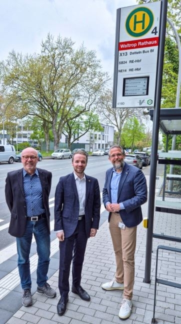 Mobilitätsmanager Burkhard Tiessen, Bürgermeister Marcel Mittelbach und ein Vertreter der VESTISCHEN (v. l.) an der Bushaltestelle Waltrop Rathaus