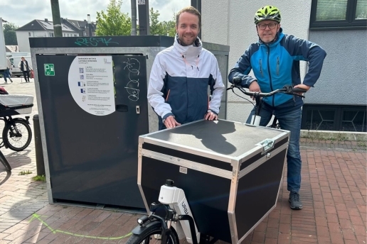 Auf dem Bild: Bürgermeister Marcel Mittelbach und Mobilitätsmanager Burkhard Tiessen (v. l.) mit einem Lastenrad auf dem Raiffeisenplatz