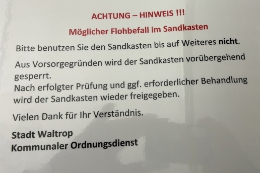 Beschilderung am abgesperrten Sandkasten des Spielplatzes in der Kreuzstraße: "Bitte benutzen Sie den Sandkasten bis auf Weiteres nicht!"