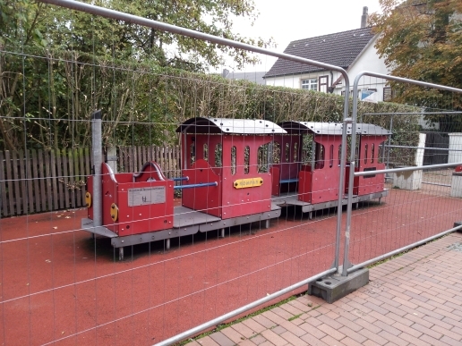 Bauzäune rund um die Spielzeuglok in der Fußgängerzone. 