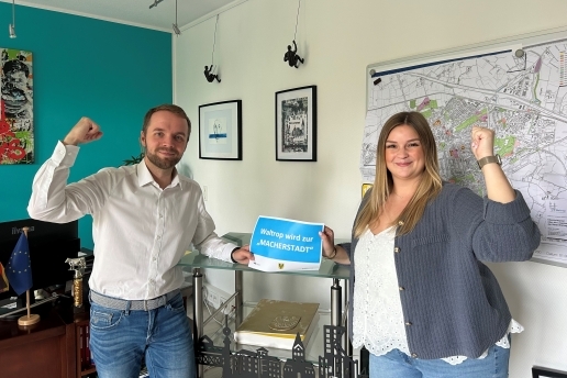 Bürgermeister Marcel Mittelbach (links) und Mitarbeiterin Melissa Neuman halten einen Zettel zur Macherstadt in die Höhe.
