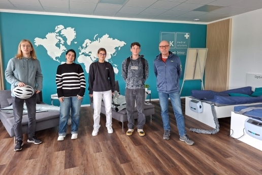 Junge Leute stehen in einem Raum beim Waltroper Unternehmen SLK und blicken in die Kamera.