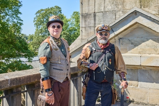 Zwei Steampunk-Darsteller stehen vor einem Gebäudeteil des Alten Schiffshebewerks in Waltrop.