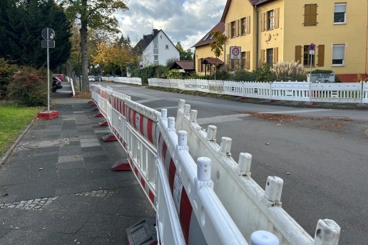 Blick in die Sydowstraße in Waltrop, Bauzäune sind zu sehen, ein Haltverbot- und ein Zone-30-Schild sowie diverse Häuser, Vorgärten und Bäume.