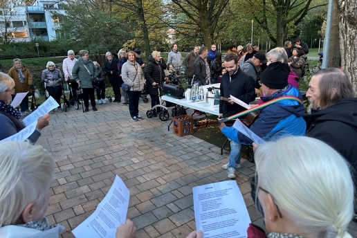 Menschen stehen mit Liedzetteln in einem Kreis bei der Eröffnung des Stutenteichparks.