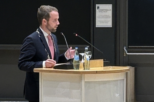 Bürgermeister Mittelbach steht an einem Rednerpult.