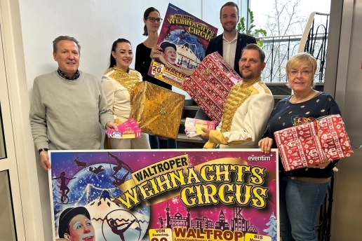 Sechs Personen stehen im Rathaus-Treppenhaus und halten Plakate und Freikarten für den Weihnachtscircus in den Händen.  