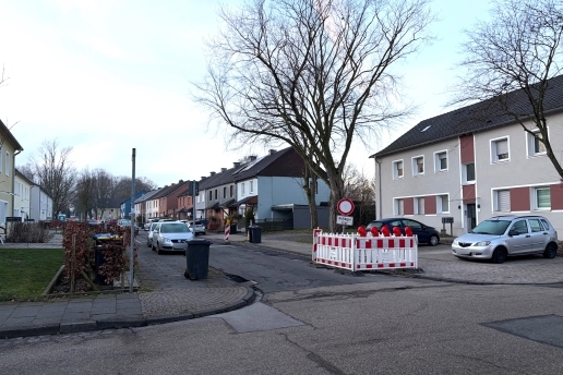 Die Stegerwaldstraße in Waltrop, Baustellen-Baken, parkende Autos, Bäume. 