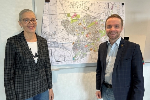 Michaela Heßelmann und Marcel Mittelbach stehen vor einer Straßenkarte der Stadt Waltrop. 