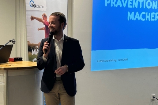 Auftaktveranstaltung Macherstadt im Foyer der Stadthalle Waltrop, Bürgermeister Marcel Mittelbach steht mit Mikro in der Hand vor einer Präsentation der IKK classic.