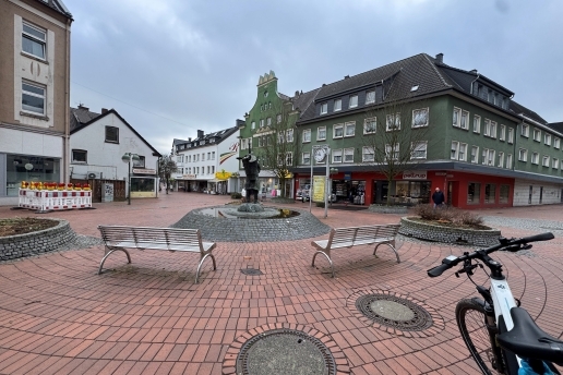 Blick auf den Platz von Gardelegen: in der Mitte der Kiepenkerlbrunnen, rundum Bänke, Baustellenzäune, im Hintergrund Bebauung.