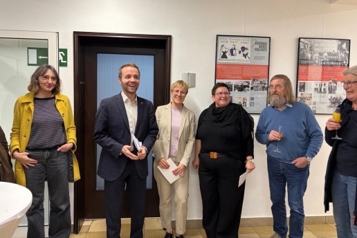 Sechs Personen stehen im Rathausflur in Waltrop vor diversen Exponaten einer Ausstellung zum Weltfrauentag. 