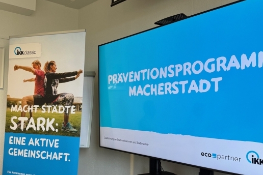 Rollup und Großbildschirm mit Darstellungen der IKK classic und des Präventionsprogramms Macherstadt