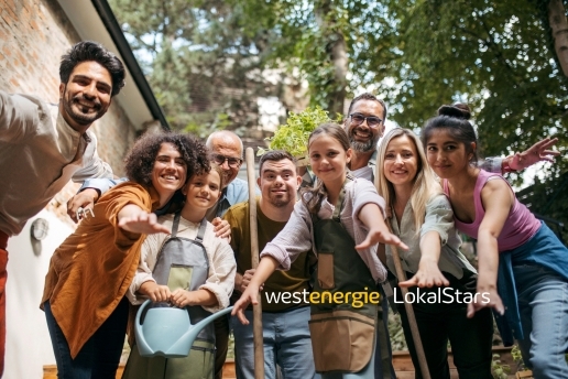 Mehrere Personen stehen vor Bäumen und einem Haus, Schrift im Bild: Westenergie LokalStars