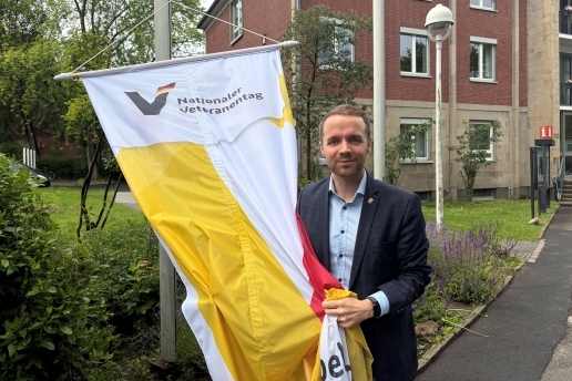 Bürgermeister Marcel Mittelbach vor dem Rathaus mit der Flagge zum Veteranentag.