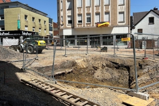 Blick auf die Baustelle Platz von Gardelegen, Häuser im Hintergrund, eine Baugrube im Vordergrund