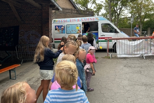 Kinder stehen vor einem Eiswagen in der Schlange. 