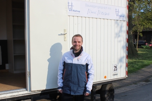 Bürgermeister Marcel Mittelbach steht vor einem Bauwagen, hinter ihm das Schild Bauwagengespräch mit Marcel Mittelbach.