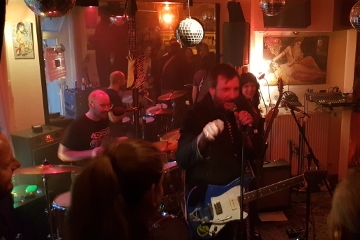 Konzert-Eindruck mit Musikern und jubelndem Publikum.