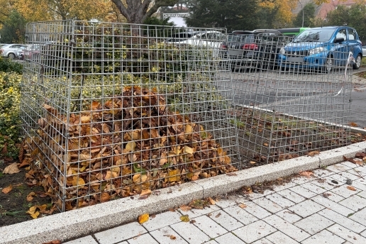 Laubkorb, im Hintergrund parkende Autos.